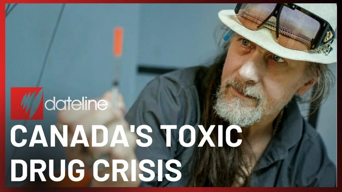 A man in a hat examines a syringe intently. The image, framed by a red border, includes text: "Dateline: Canada's Toxic Drug Crisis."