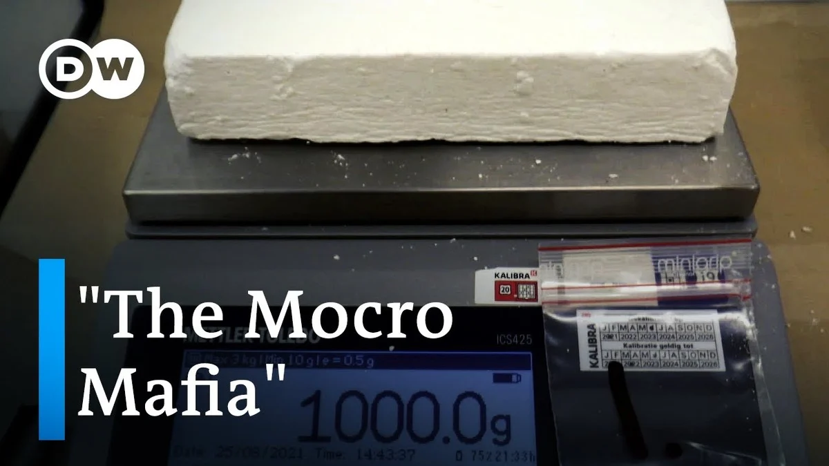 A large white brick, likely a drug package, sits on a scale displaying "1000.0g." The words "The Mocro Mafia" and "DW" logo overlay the image.