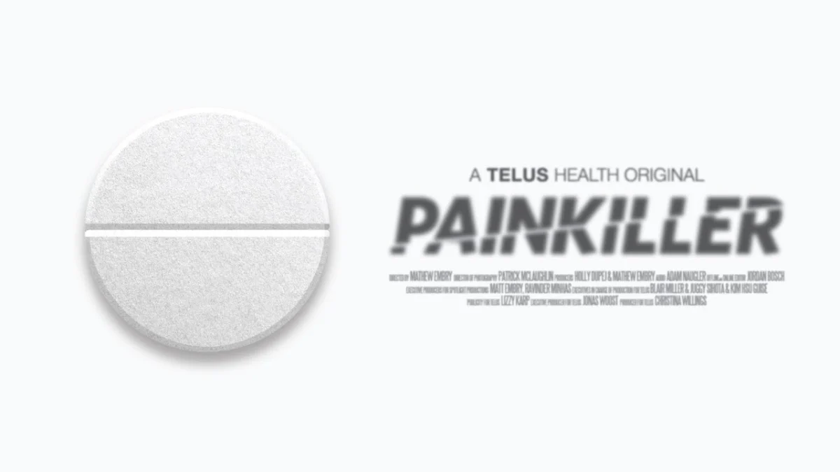 Close-up of a white round pill with a scored line on the left. To the right, blurred text reads 'A Telus Health Original: Painkiller.' The tone conveys a medical or pharmaceutical theme.